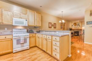 a kitchen with wooden cabinets and white appliances at Collins Lake Condo in Government Camp