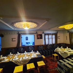 Hôtel Restaurant La Gazelle De Dades في Akhendachou nʼAït Ouffi: غرفة طعام بها طاولات وكراسي وشاشة