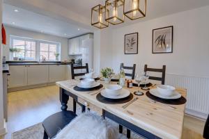 een keuken en eetkamer met een houten tafel en stoelen bij Kist Accommodates - Duck Hill Cottage in Ripon