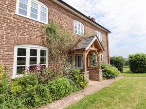 a brick house with an arched entry door at Henhouse Farm in Hereford