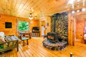 een woonkamer met een open haard in een blokhut bij Lost Pond Cabin in Schroon Lake