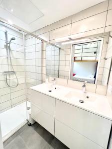 - une salle de bains blanche avec deux lavabos et une douche dans l'établissement Magnifique Villa Neuve Vue Mer, à Cavalaire-sur-Mer