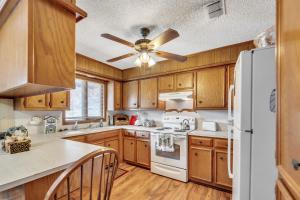 a kitchen with wooden cabinets and a ceiling fan at Homestead House - In Shadow Hills Golf Course Division Home in Lubbock