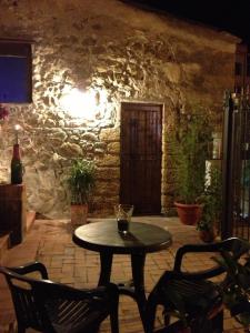 a table and chairs in a room with a stone wall at Mulino in Cefalù
