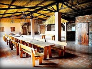 a row of wooden tables and benches in a building at Hotel Arkadia in Legnica
