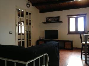 a living room with a couch and a television at Mulino in Cefalù