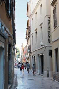 a group of people walking down a street with buildings at Art Hotel Kalelarga in Zadar