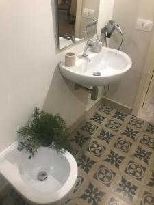 a bathroom with a sink and a toilet with a plant on it at L’antica stella in Modica