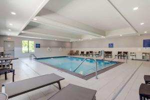 een groot zwembad in een hotelkamer met tafels en stoelen bij Best Western Plus Choctaw Inn & Suites in Choctaw