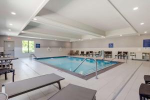 a large pool in a hotel room with tables and chairs at Best Western Plus Choctaw Inn & Suites in Choctaw