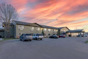 a parking lot with cars parked in front of a building at Best Western Pinedale Inn in Pinedale