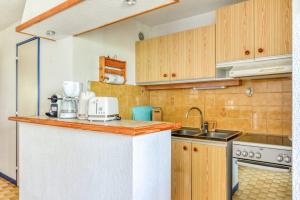 una cucina con mobili in legno e un piano di lavoro di Studio cabine Viktoria a Gruissan Altre 5 foto