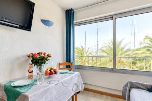 une table avec un vase de fruits et une fenêtre dans l'établissement Studio cabine Viktoria, à Gruissan