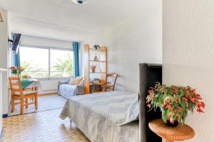 - une chambre avec un lit et une table avec une plante dans l'établissement Studio cabine Viktoria, à Gruissan