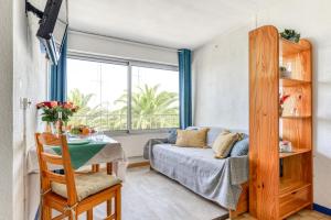 1 dormitorio con cama, mesa y ventana en Studio cabine Viktoria, en Gruissan