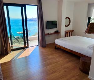 1 dormitorio con cama y vistas al océano en Hotel Kanes en Sarandë