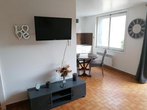 a living room with a flat screen tv on a wall at Au chant des oiseaux in Hennecourt