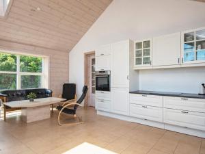 a kitchen with white cabinets and a table at 8 person holiday home in B rkop in Børkop
