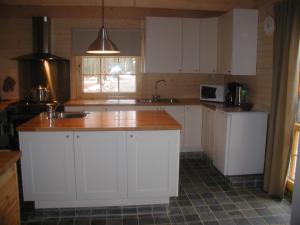 uma cozinha com armários brancos e um balcão de madeira em Le Gibier - Vakantiewoning em Bomal