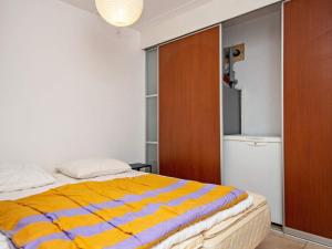 ボルコップにある8 person holiday home in B rkopのベッドルーム1室(黄色と青のストライプの毛布付きのベッド1台付)