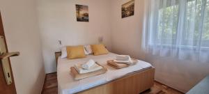 a bedroom with a bed with towels on it at Apartments Anica Beber in Borovići