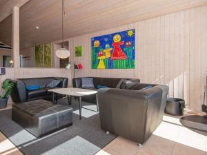 a living room with leather furniture and a painting on the wall at 6 person holiday home in Tarm in Hemmet