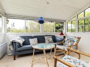 a living room with a blue couch and chairs at 6 person holiday home in Bindslev in Bindslev
