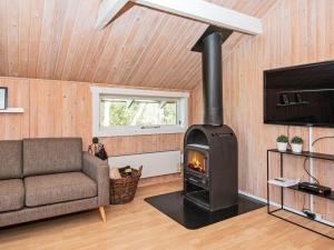 エーベルトフトにある6 person holiday home in Ebeltoftのリビングルーム(暖炉、ソファ付)