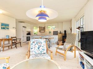 a living room with a table and chairs at 6 person holiday home in Bindslev in Bindslev