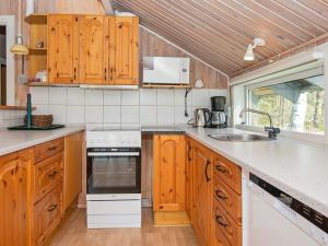 エーベルトフトにある6 person holiday home in Ebeltoftのキッチン(木製キャビネット、シンク付)