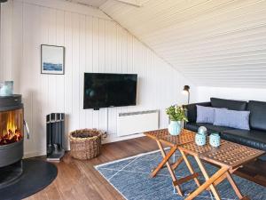 a living room with a couch and a fireplace at Three-Bedroom Holiday home in Hemmet 90 in Falen