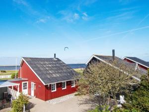 a red house with a bird flying above it at Three-Bedroom Holiday home in Hemmet 90 in Falen