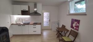 a kitchen with white cabinets and a sink and a table at Studio Marjetica in Zgornje Gorje