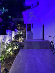 a purple house with stairs and a bike parked at Kanes Boutique Hotel in Sarandë