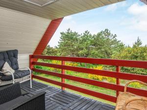 a porch with a chair and a view of trees at 7 person holiday home in Ulfborg in Fjand Gårde