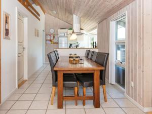 a dining room with a wooden table and black chairs at 6 person holiday home in Hemmet in Hemmet