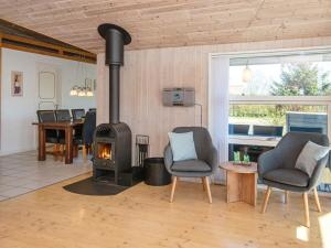 a living room with two chairs and a wood stove at 6 person holiday home in Hemmet in Hemmet