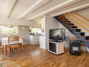 uma sala de estar com televisão e uma escadaria em Three-Bedroom Holiday home in Hurup Thy 8 em Sindrup