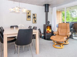 a dining room with a table and chairs and a fireplace at 6 person holiday home in Hemmet in Falen