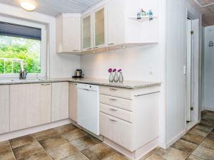 a kitchen with white cabinets and a window at 6 person holiday home in Hemmet in Falen