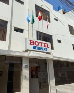 un hotel con banderas en la parte superior de un edificio en Hotel Begonias en Lambayeque
