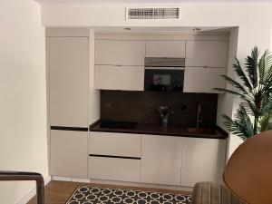uma cozinha com armários brancos num quarto em Loft de lujo con piscina LA ENVIA em Vícar