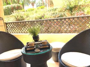 a patio with two chairs and a table with a plant on it at Loft de lujo con piscina LA ENVIA in Vícar