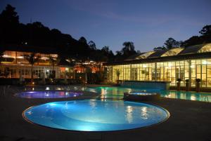 oświetlony basen przed budynkiem w nocy w obiekcie Villagio Embu w mieście Embu