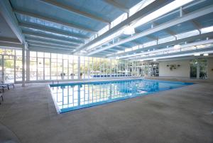 duży basen w dużym budynku z oknami w obiekcie Villagio Embu w mieście Embu