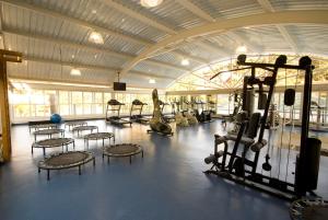 un gimnasio con filas de equipos de ejercicio en un edificio en Villagio Embu en Embu