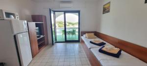 a kitchen with a couch and a door to a balcony at Apartments Anica Beber in Borovići