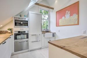 a kitchen with white cabinets and a counter top at Steps to NYC Train! Charming Carriage House Loft in Glen Ridge +16 photos