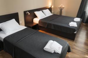 a hotel room with two beds with towels on them at Family Hotel Pautalia in Sandanski