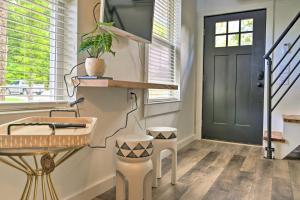 un pasillo con una puerta negra, una mesa y un taburete en Modern Starkville Tiny Home Near Dining and MSU, en Starkville